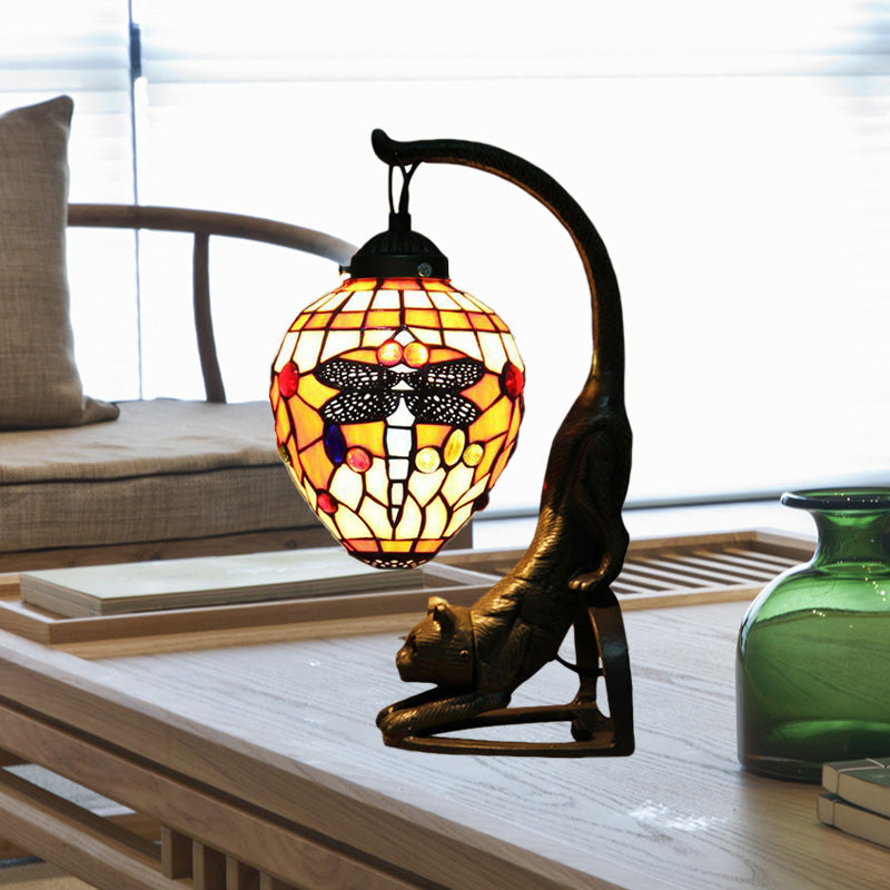 Decorative cat-shaped table lamp with a coloured glass shade